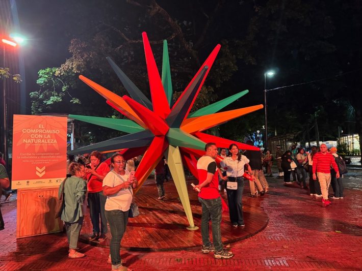 People stood around a colourful spikey sculpture in Cali's Green Zone during COP16.